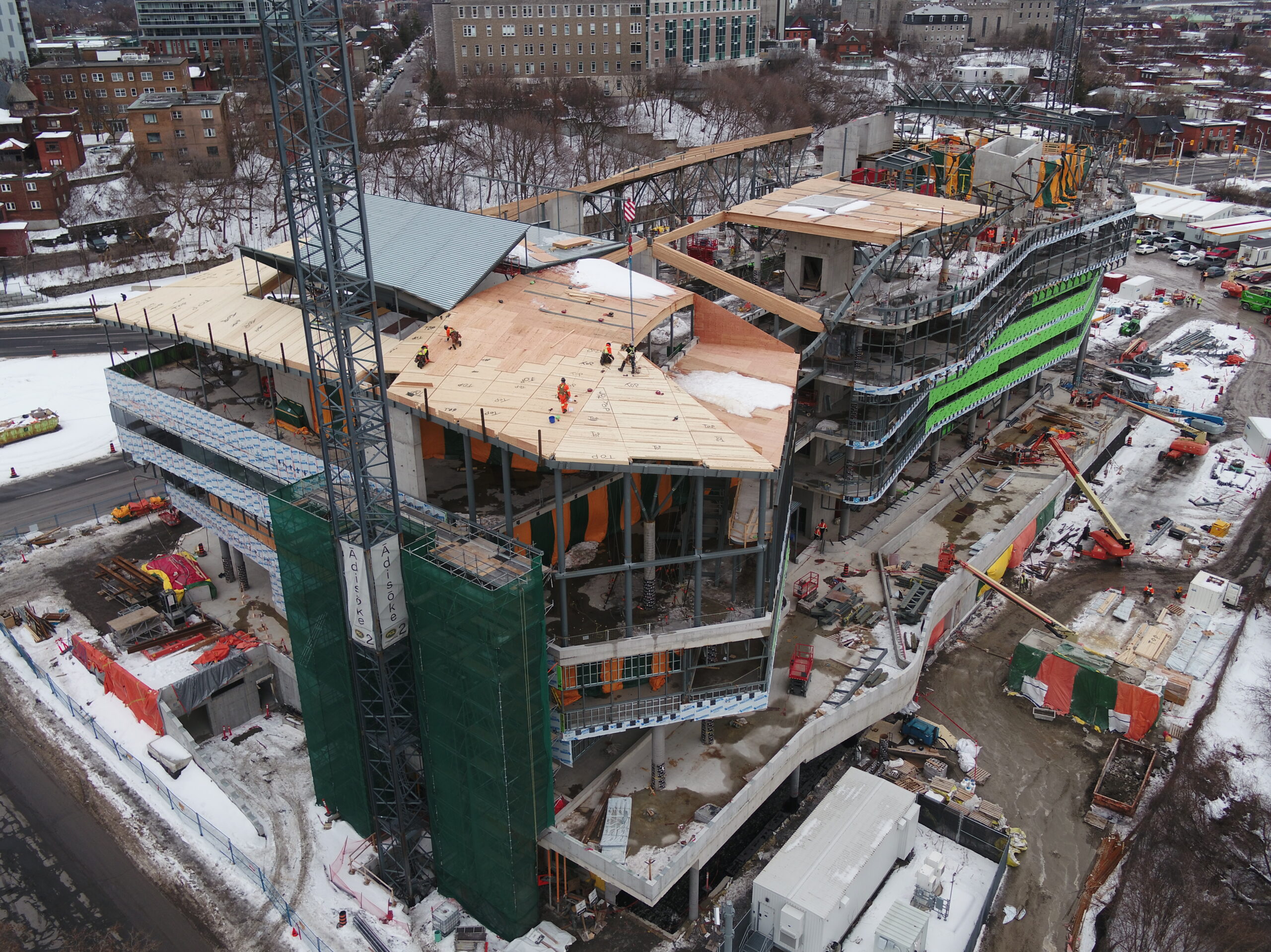 Construction du bâtiment Ādisōke : cinq ouvriers installent les pans de toiture.