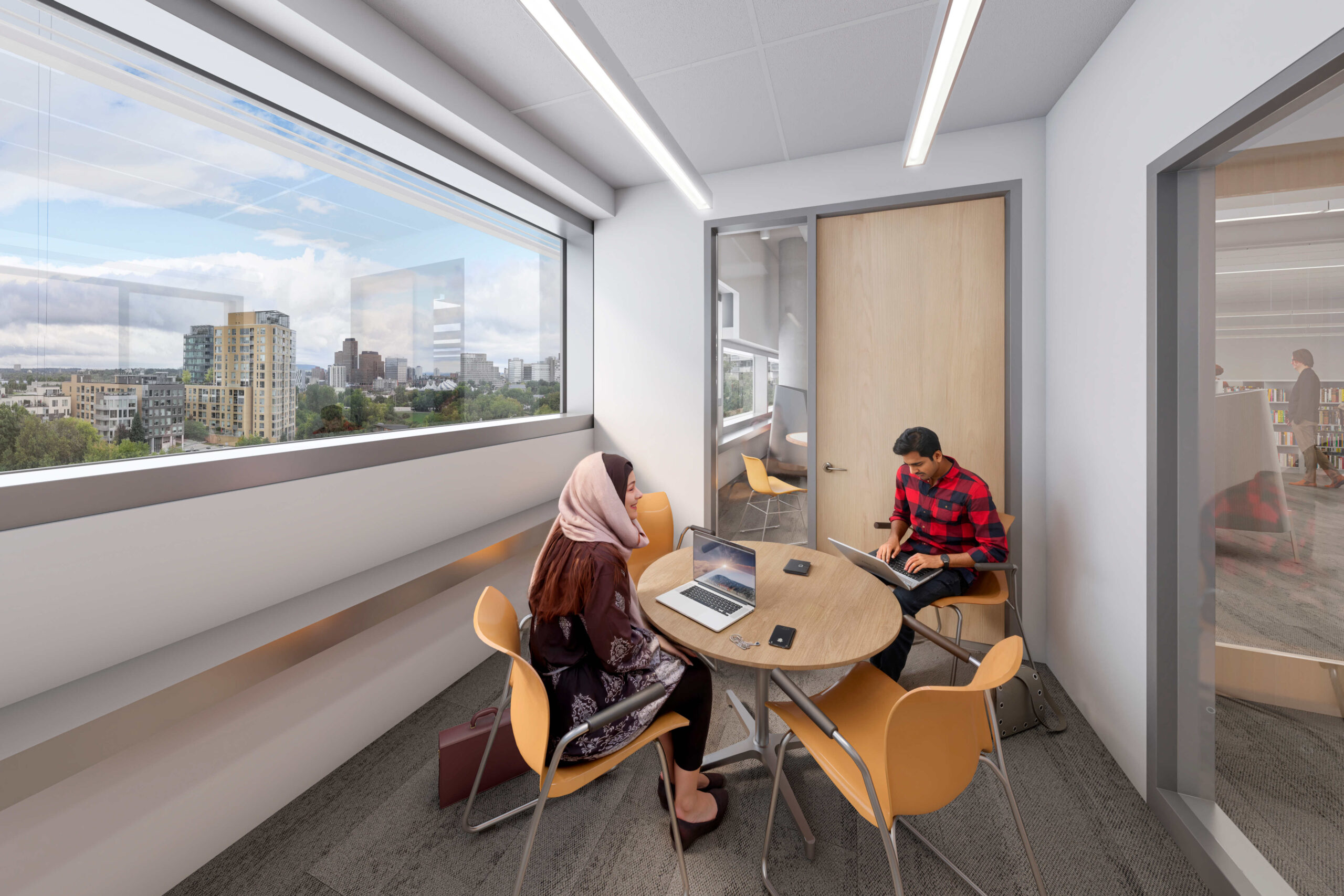 Deux personnes assises à une table ronde dans une pièce avec des fenêtres.