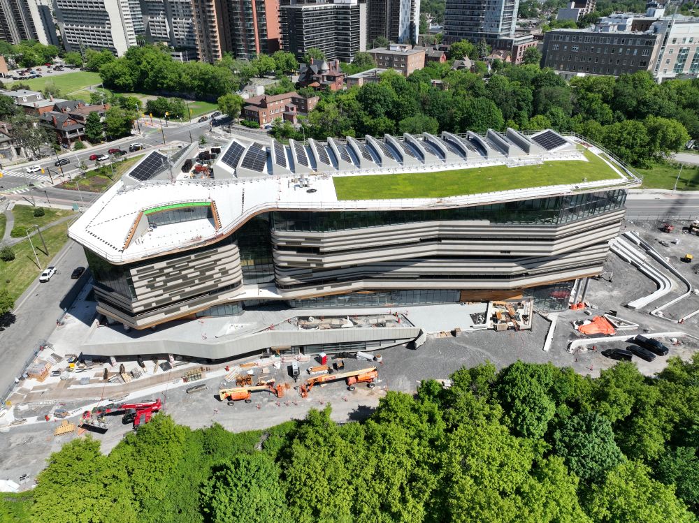 Aerial view of Ādisōke showing the exterior façade including a green roof and solar panels.